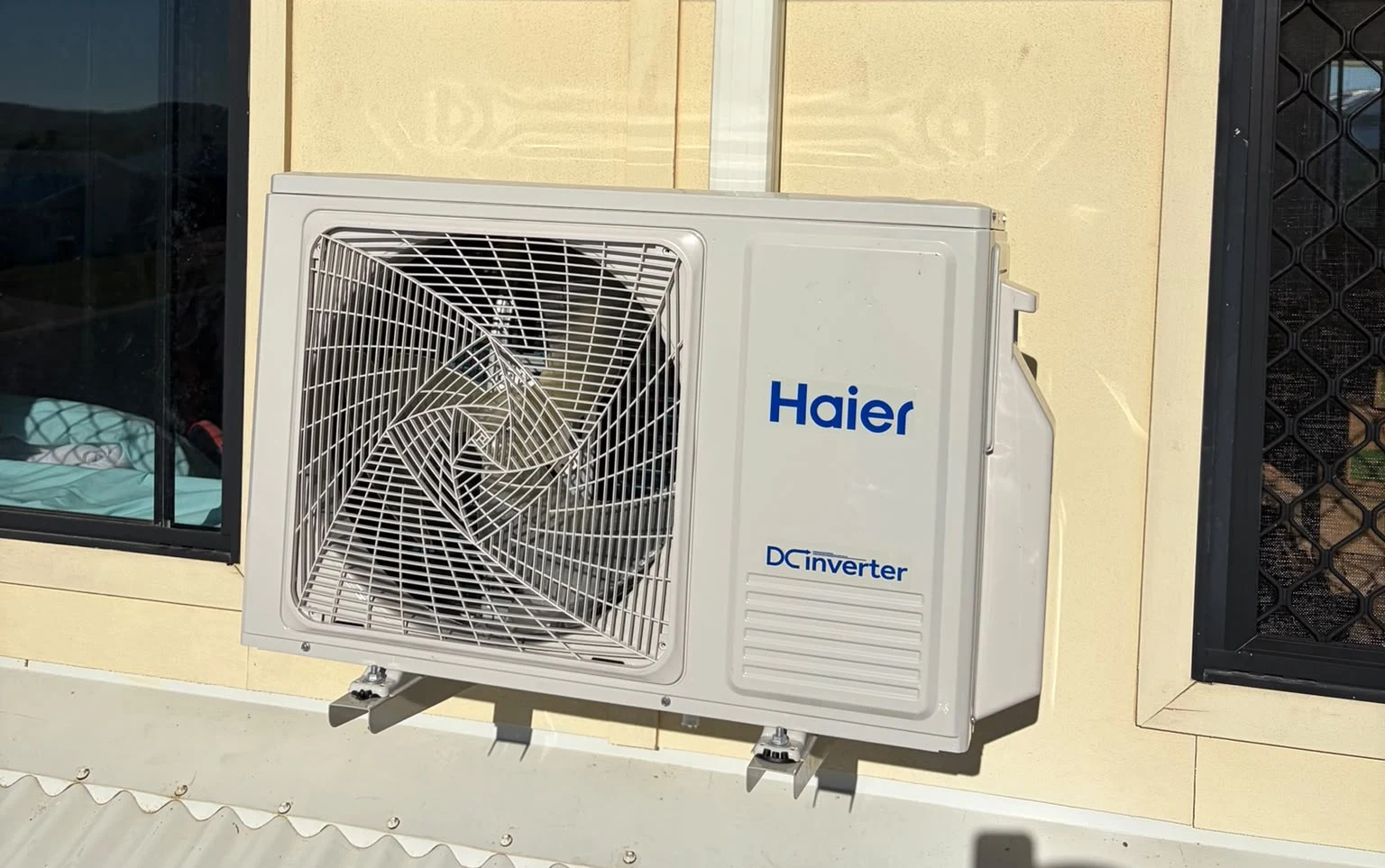 Haier DC inverter split-system outdoor unit neatly installed on brick wall of residential property